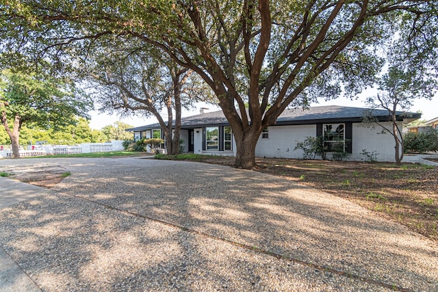 ranch-style home with brick siding and fence