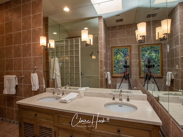 bathroom featuring vanity, a skylight, tile walls, and a shower with shower door