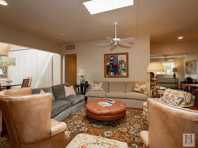 living room with ceiling fan and a skylight