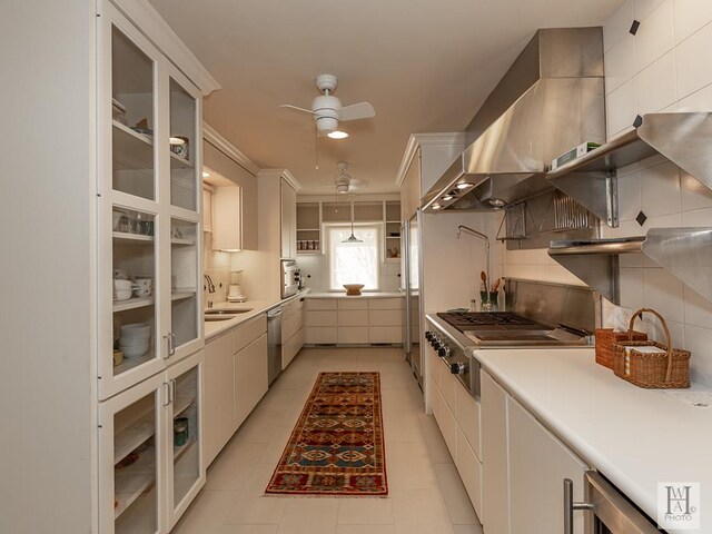 kitchen featuring appliances with stainless steel finishes, ceiling fan, crown molding, and wall chimney range hood