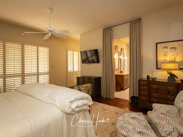 bedroom with dark parquet flooring, connected bathroom, and ceiling fan