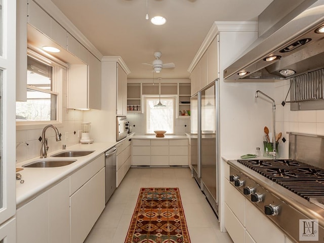 kitchen featuring white cabinets, pendant lighting, wall chimney exhaust hood, and sink