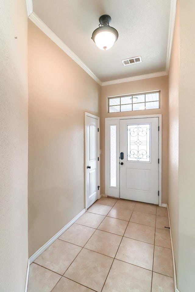 entrance foyer with crown molding and light tile patterned floors