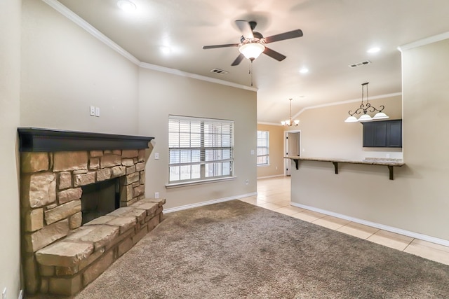 living room with ornamental molding, a stone fireplace, light tile patterned floors, and ceiling fan with notable chandelier