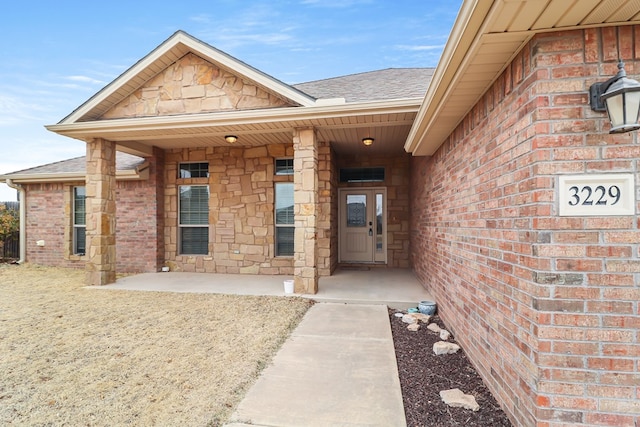 view of exterior entry with a patio