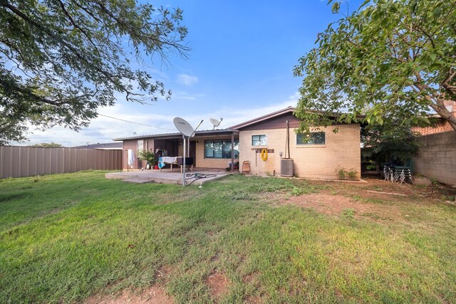 704 Birdwell Ln, Big Spring, TX 79720 - rear view of house with a fenced backyard, a patio, and brick siding