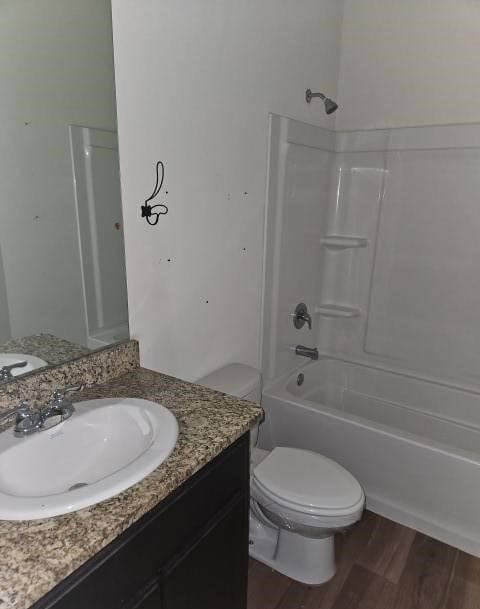 full bathroom with washtub / shower combination, vanity, toilet, and wood finished floors