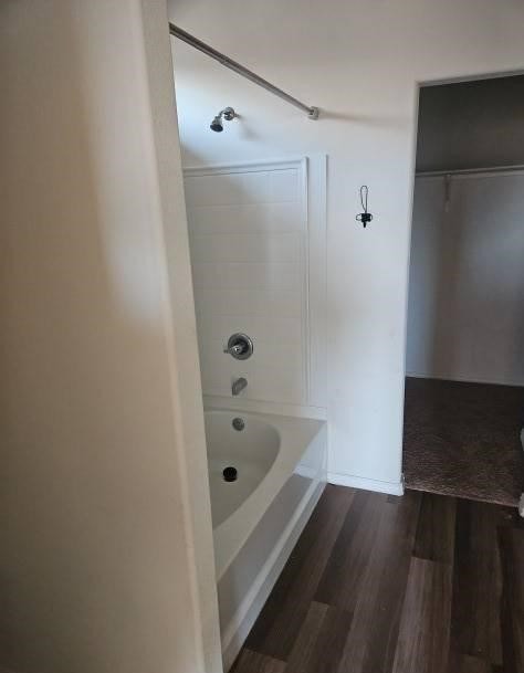 full bath with shower / bathing tub combination, wood finished floors, and baseboards