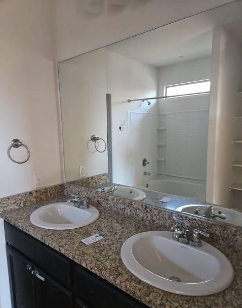 full bathroom featuring double vanity and a sink