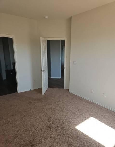 unfurnished bedroom with carpet floors and baseboards