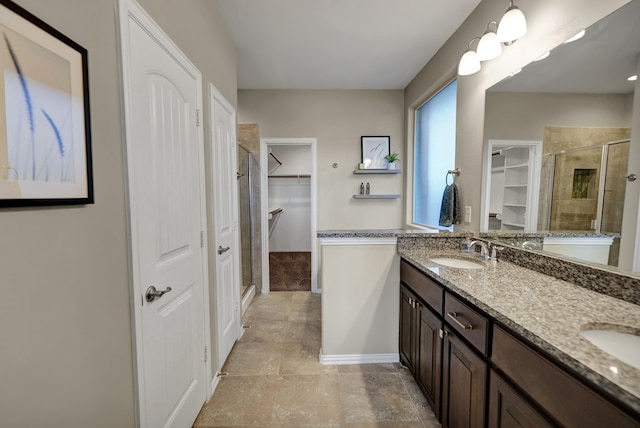 bathroom with a shower with shower door and vanity