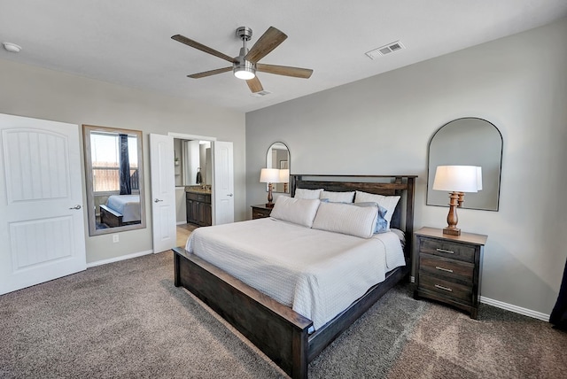 bedroom with ceiling fan, dark carpet, and ensuite bathroom