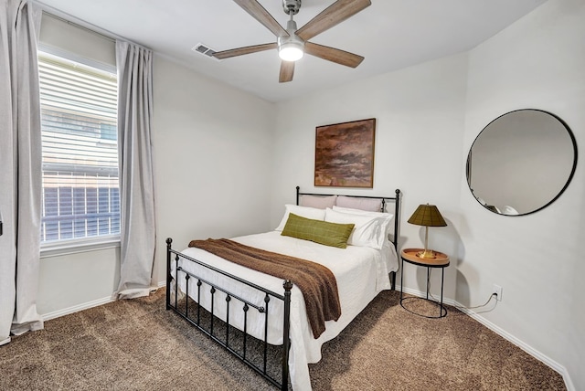 carpeted bedroom featuring ceiling fan and multiple windows