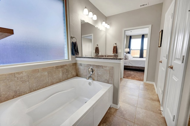 bathroom featuring tiled tub and tile patterned floors