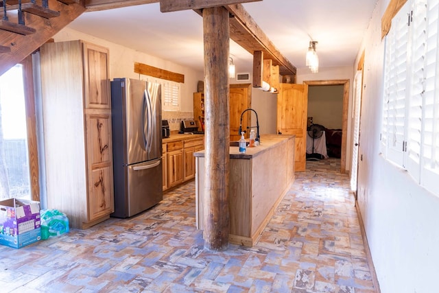 kitchen with stainless steel fridge, sink, and light brown cabinets