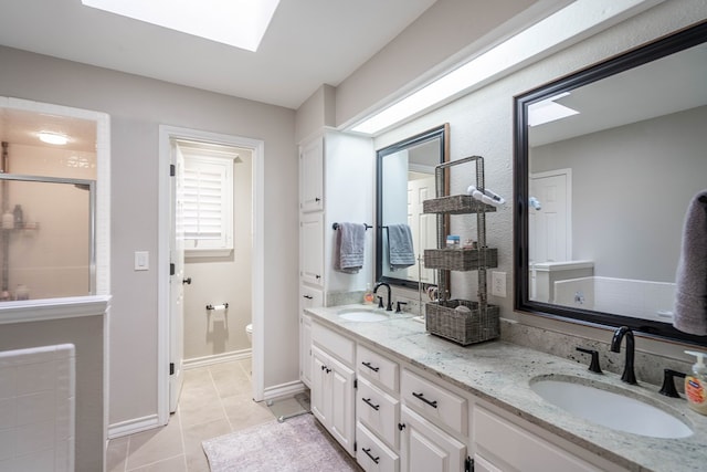 bathroom featuring a skylight, tile patterned floors, an enclosed shower, vanity, and toilet