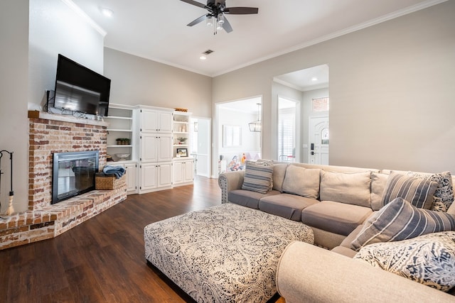 living room featuring ceiling fan, dark hardwood / wood-style flooring, ornamental molding, and a fireplace