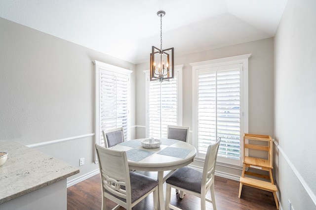 dining space featuring dark hardwood / wood-style floors and an inviting chandelier