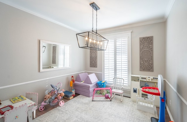 recreation room with wood-type flooring, crown molding, and an inviting chandelier