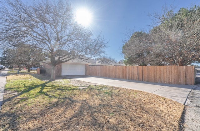 view of side of property featuring a garage and a yard