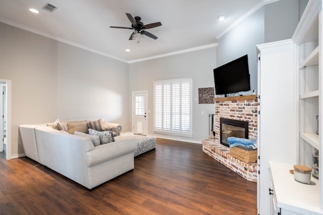 living room with a fireplace, ornamental molding, ceiling fan, and dark wood-type flooring