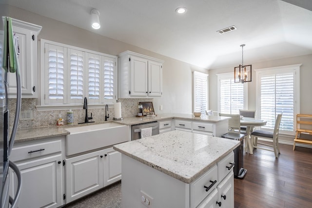 kitchen featuring white cabinets, decorative backsplash, a kitchen island, and sink