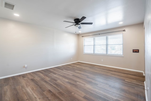 spare room featuring dark hardwood / wood-style flooring and ceiling fan