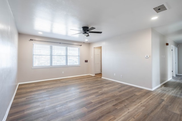 spare room with dark hardwood / wood-style flooring and ceiling fan