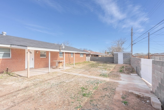 view of yard featuring a storage unit and a patio