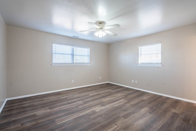 unfurnished room featuring plenty of natural light, ceiling fan, and dark hardwood / wood-style flooring