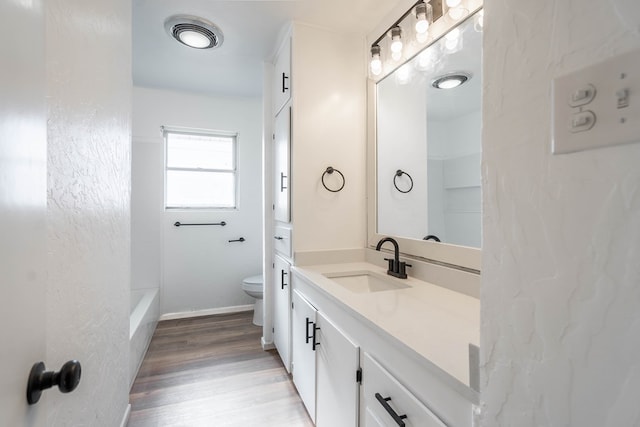 full bathroom featuring vanity, toilet, wood-type flooring, and bathing tub / shower combination