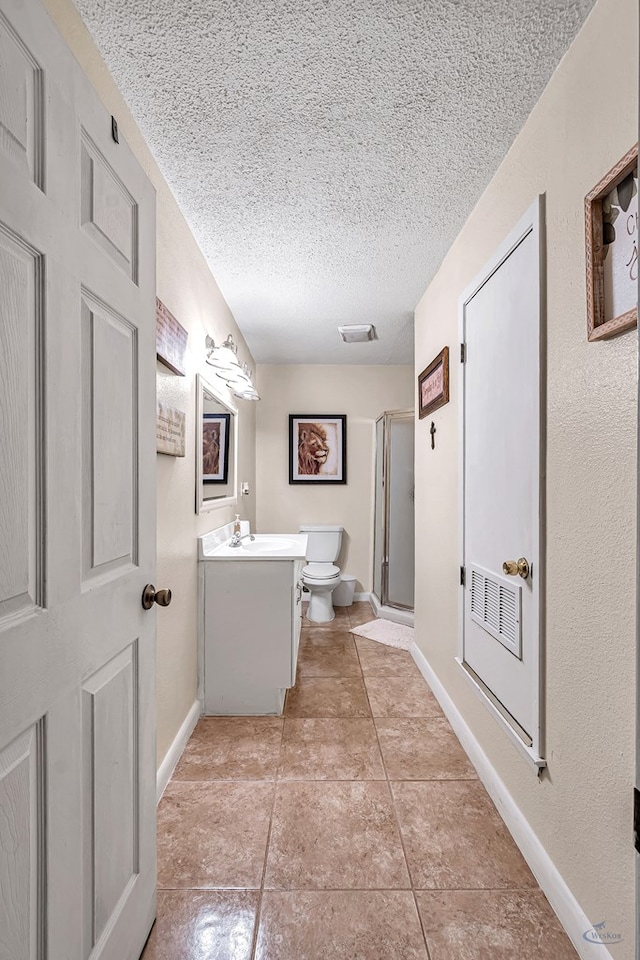 3409 Wedgwood, Midland, TX 79707 - bathroom with vanity, toilet, a textured ceiling, tile patterned floors, and a stall shower