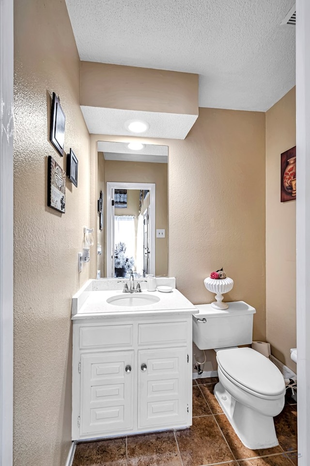 3409 Wedgwood, Midland, TX 79707 - half bathroom with vanity, a textured wall, toilet, and a textured ceiling