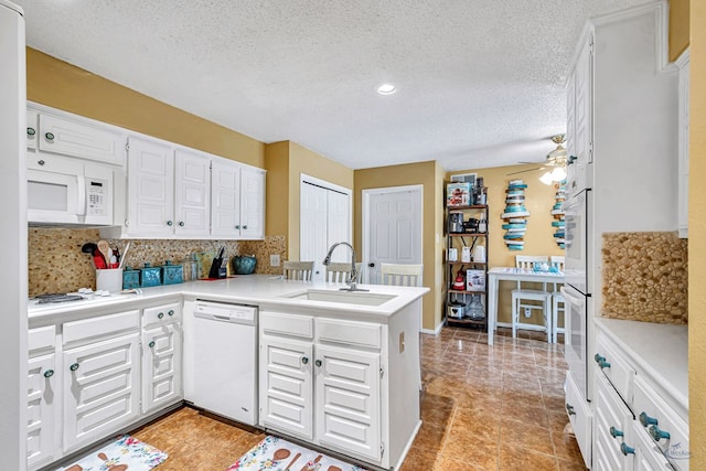 3409 Wedgwood, Midland, TX 79707 - kitchen featuring white cabinets, a sink, white appliances, a peninsula, and tasteful backsplash