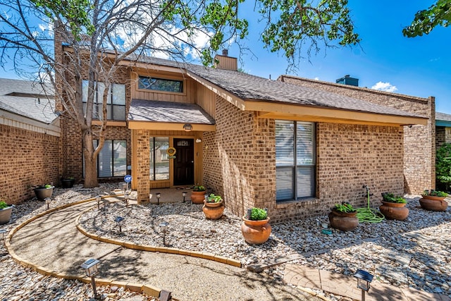 3409 Wedgwood, Midland, TX 79707 - rear view of house with a shingled roof, a chimney, and brick siding