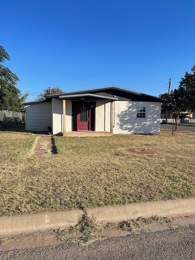 view of front of property featuring a front lawn and fence