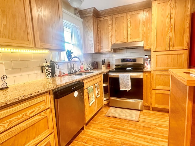 kitchen with appliances with stainless steel finishes, tasteful backsplash, sink, light hardwood / wood-style floors, and light stone countertops