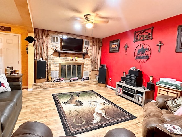 living room featuring wood-type flooring and a brick fireplace