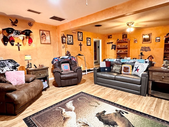 living room with hardwood / wood-style flooring, beamed ceiling, and ceiling fan