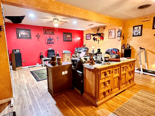 office area featuring ceiling fan, wood-type flooring, and beam ceiling