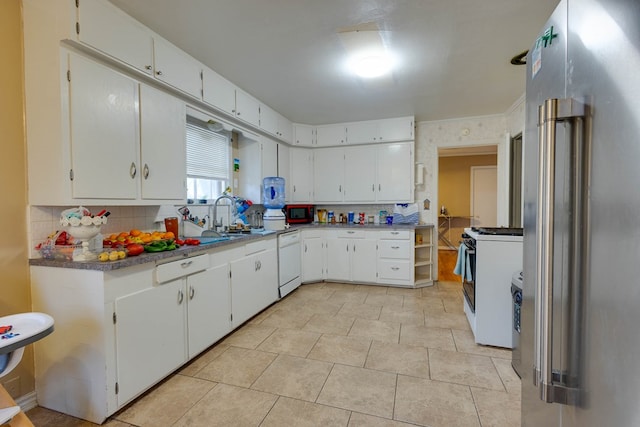 1603 Sycamore St, Big Spring, TX 79720 - kitchen featuring white appliances, tasteful backsplash, a sink, and white cabinets