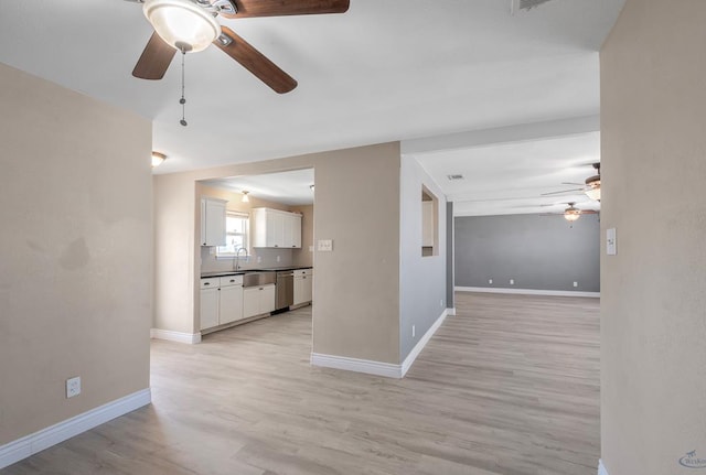 unfurnished living room featuring ceiling fan, sink, and light hardwood / wood-style floors