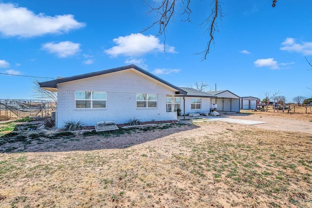 rear view of property with fence and brick siding