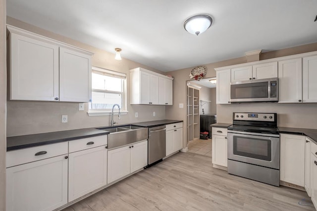 kitchen featuring white cabinetry, stainless steel appliances, light hardwood / wood-style floors, and sink