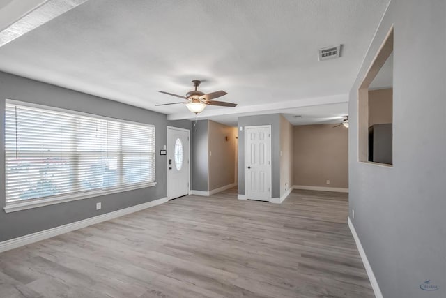 foyer entrance with light hardwood / wood-style floors and ceiling fan