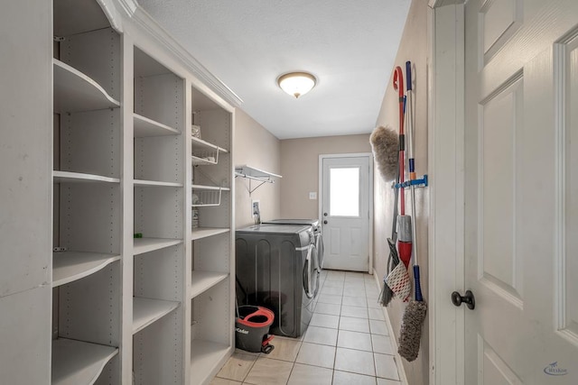 washroom with light tile patterned floors and washer and clothes dryer