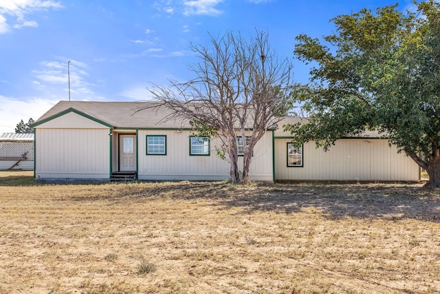 rear view of property featuring a lawn