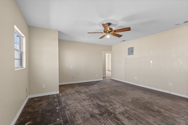 spare room featuring dark hardwood / wood-style floors, ceiling fan, and electric panel