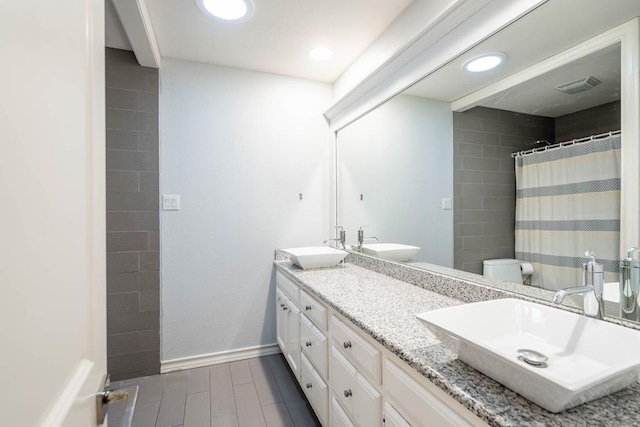 4508 Island Dr, Midland, TX 79707 - full bathroom with double vanity, toilet, baseboards, a shower with curtain, and recessed lighting