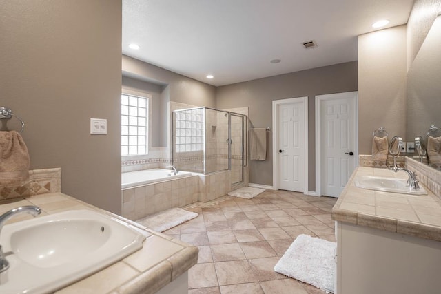 4508 Island Dr, Midland, TX 79707 - full bathroom featuring double vanity, a garden tub, a stall shower, recessed lighting, and baseboards